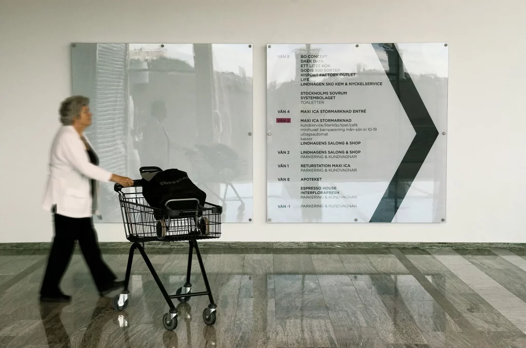 En kvinna går förbi en inomhusskylt i akryl.