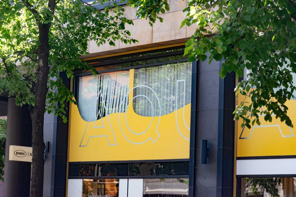 En bild på utsidan av Aqua dental med gula fönster. 