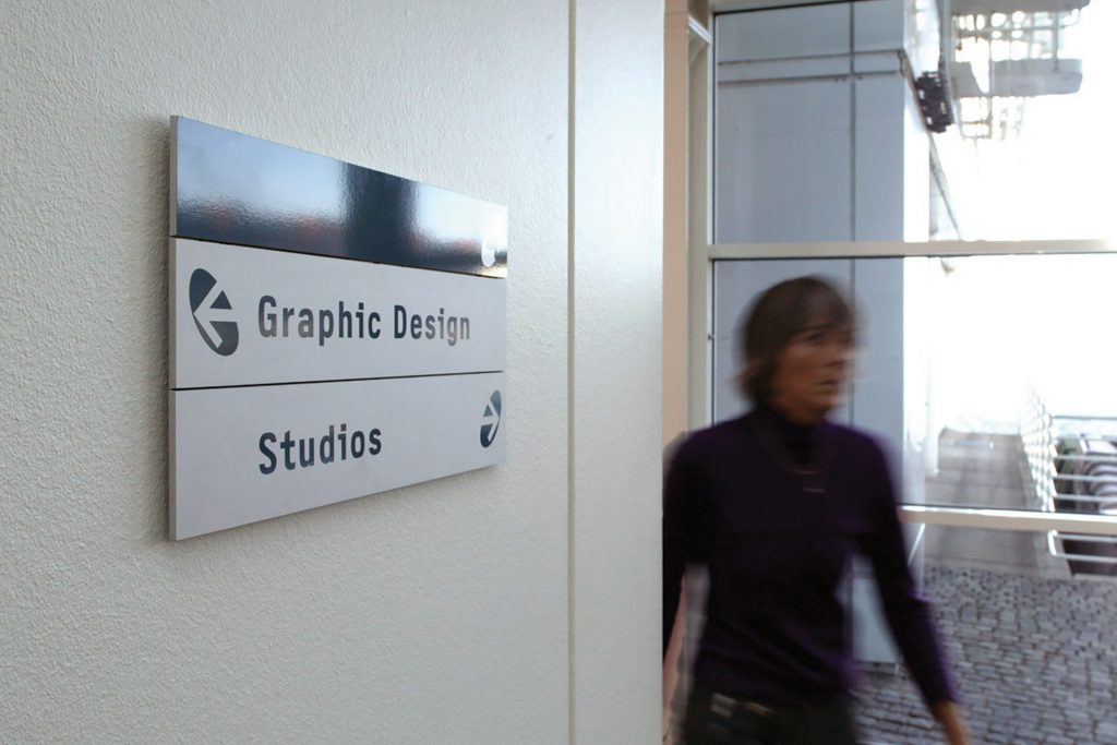 Plansign hänvisningsskylt och en person som går.