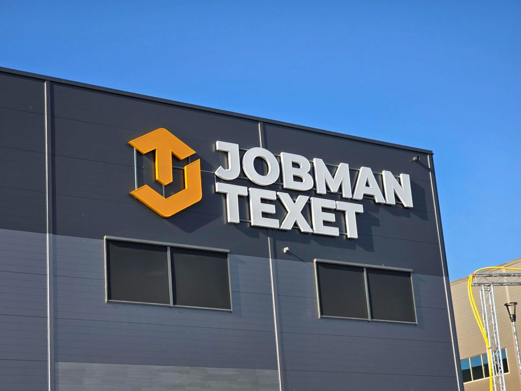 Jobman textet skylt med text och logga på byggnad. 