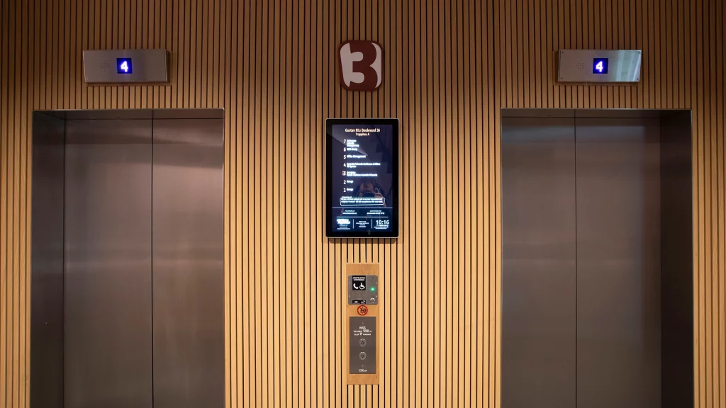 En hiss med två dörrarr och trävägg. 