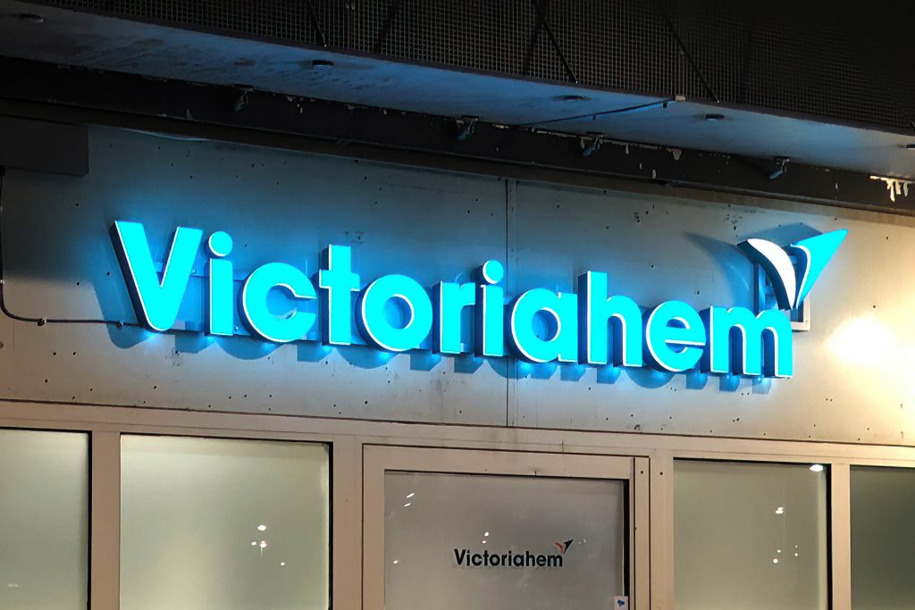 En ljusblå lysande skylt som säger Victoriahem.